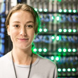 Caucasian woman technician in a large computer server farm.