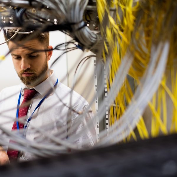 Technician checking cables in a rack mounted server