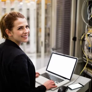 Technician using laptop while analyzing server