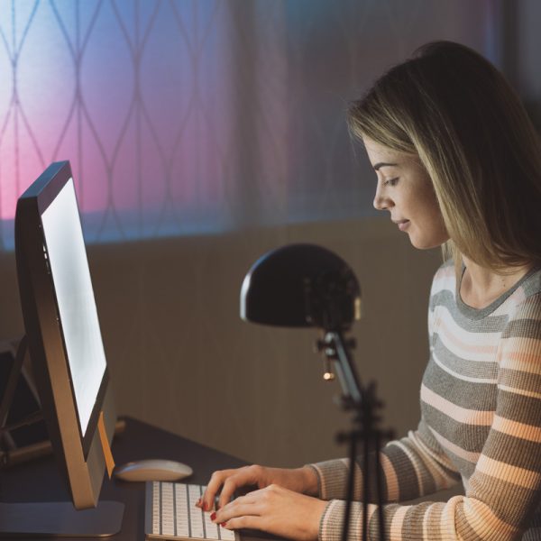 Young smiling woman social networking with her computer